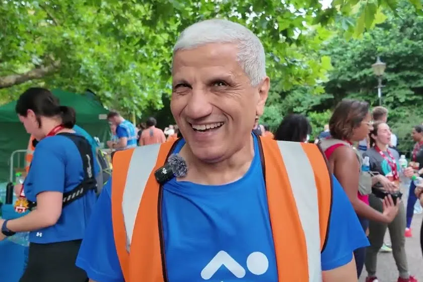 A smiling RunThrough volunteer in a hi-vis vest at the finish of a race