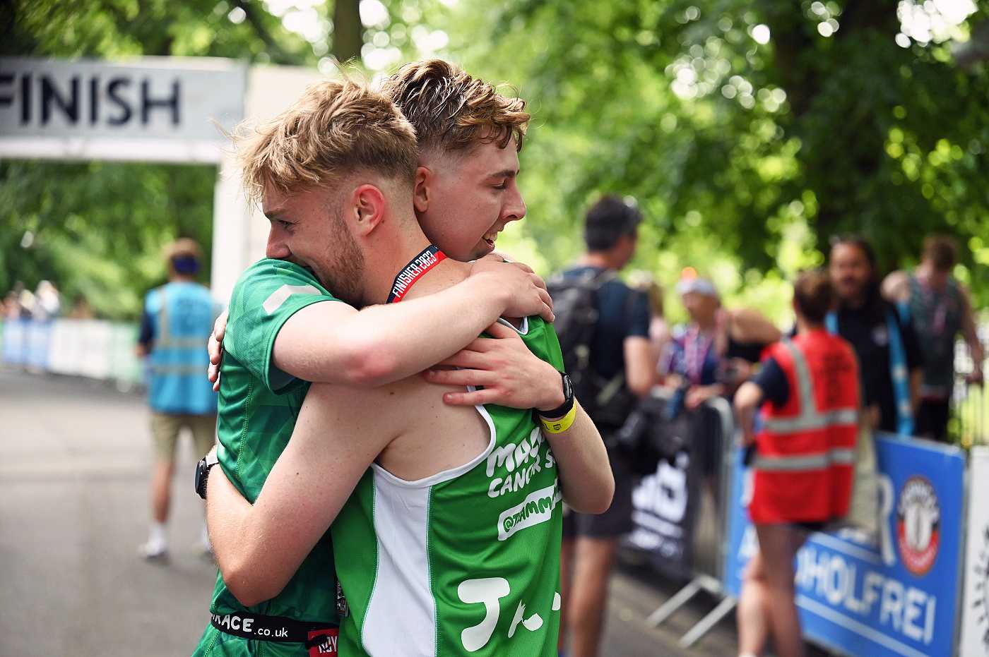 Two Team Macmillan finishers hugging at the finish line