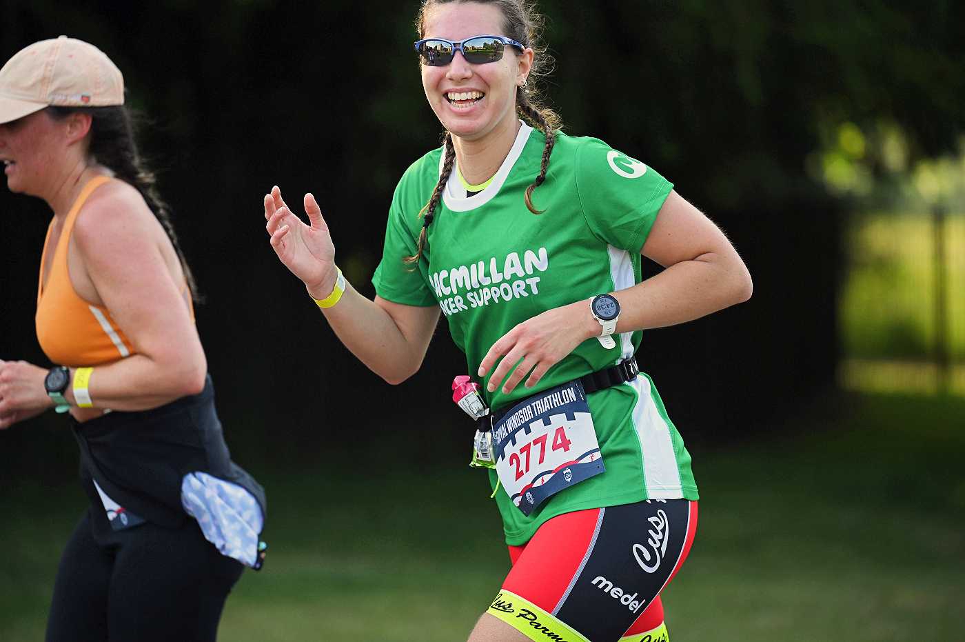 A smiling Team Macmillan triathlete on the run