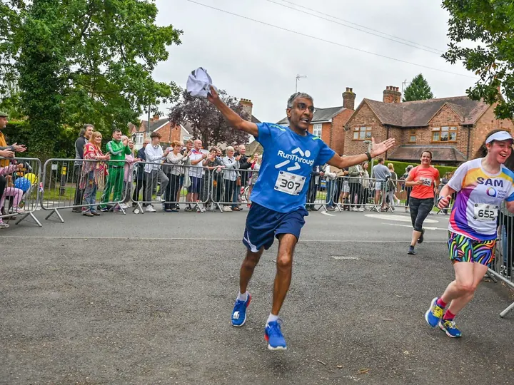 A runner celebrating as they cross a RunThrough finish line